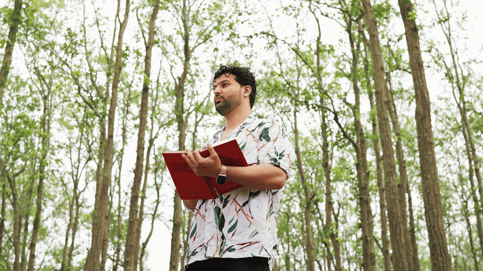 Psychic medium Daksh outdoors in a forest, connecting with spirits.