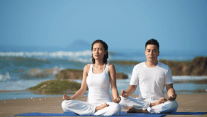 Meditating individuals practicing spiritual detachment and inner peace by the ocean.